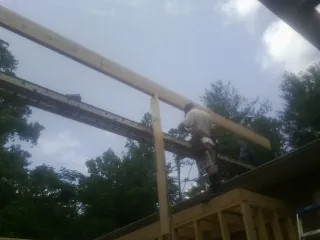 Carpenter setting a ridge beam over a new addition frame — Ice Dam Removal by Roofing Brothers in Elora