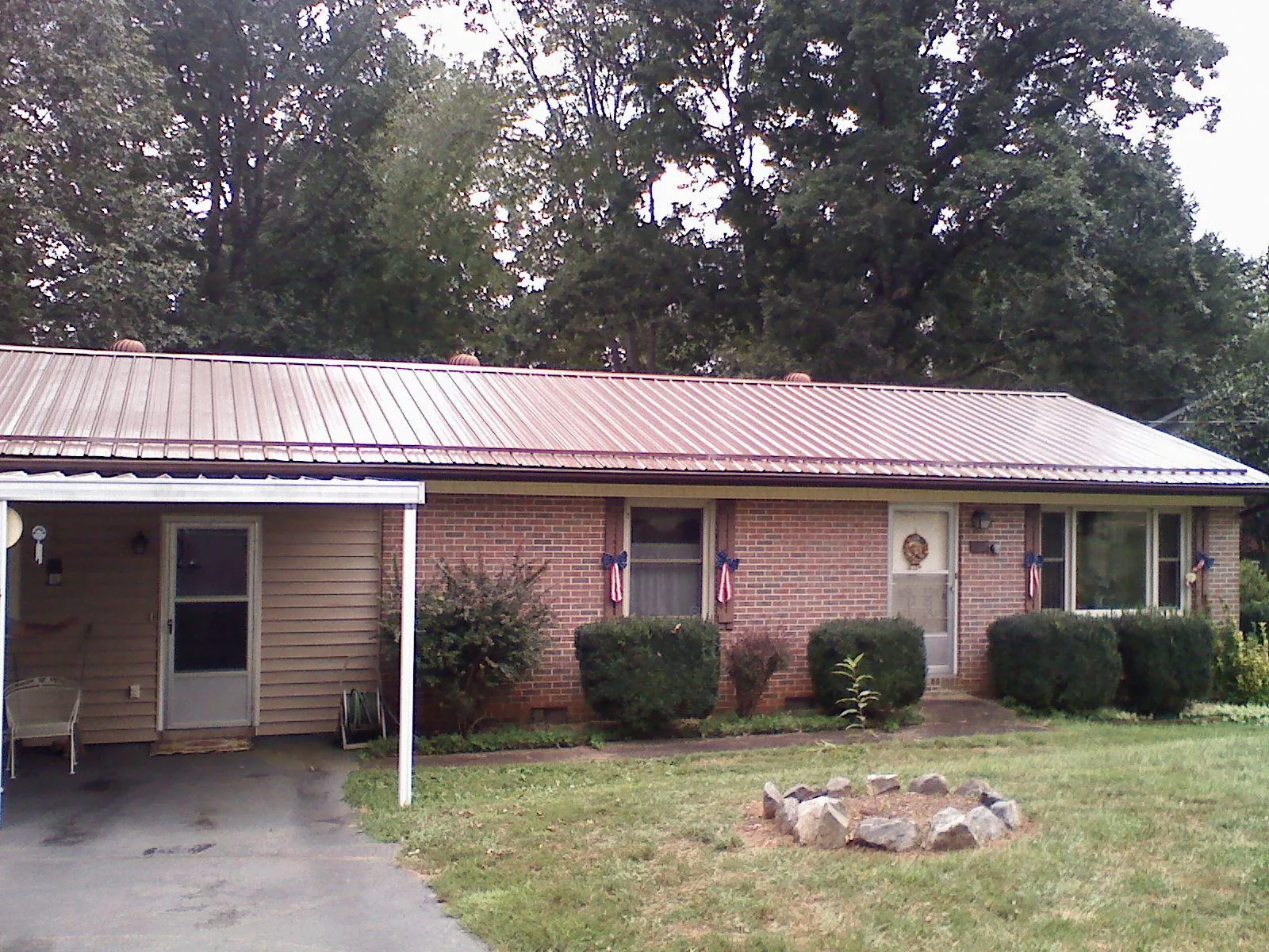 Bronze metal roof and carport on a brick ranch home — Roof Repair work by our crew in Elora
